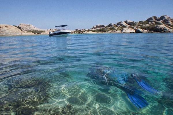 Catamaran anchored off a granite island in clear turquoise water