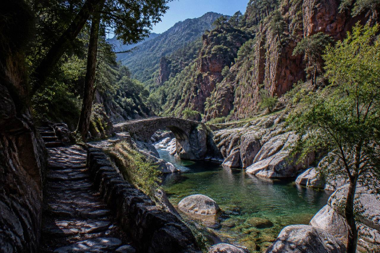 A mountain stream running through granite rocks under Corsican sunshine
