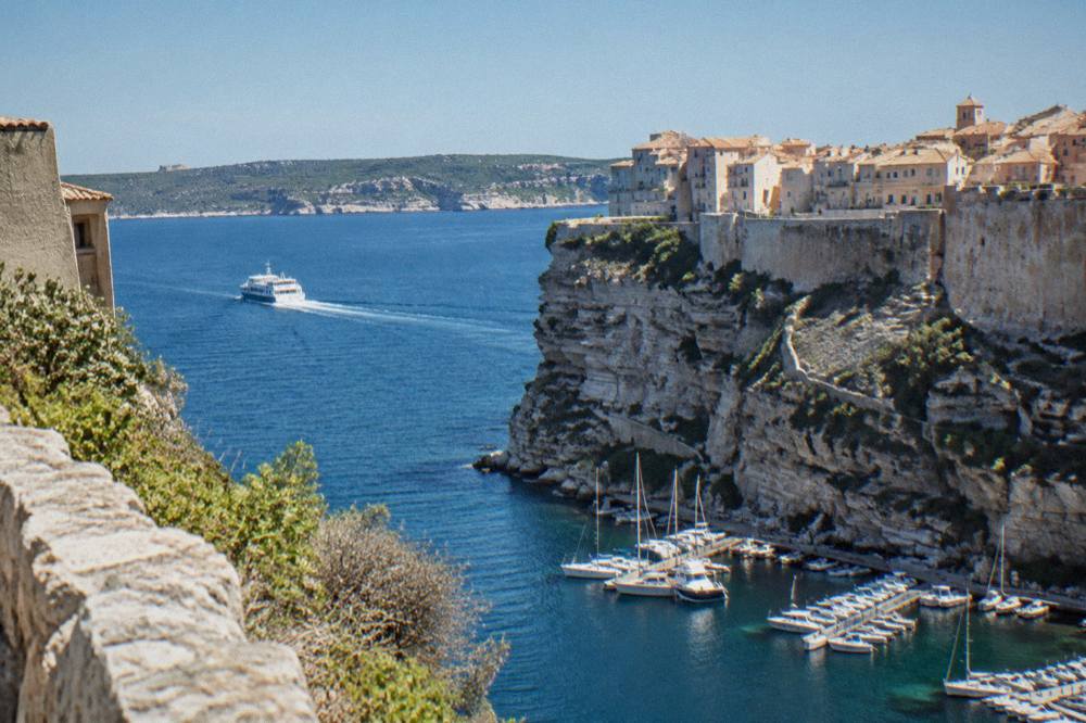A small ferry crossing the blue strait between Bonifacio in Corsica and the Sardinian coast