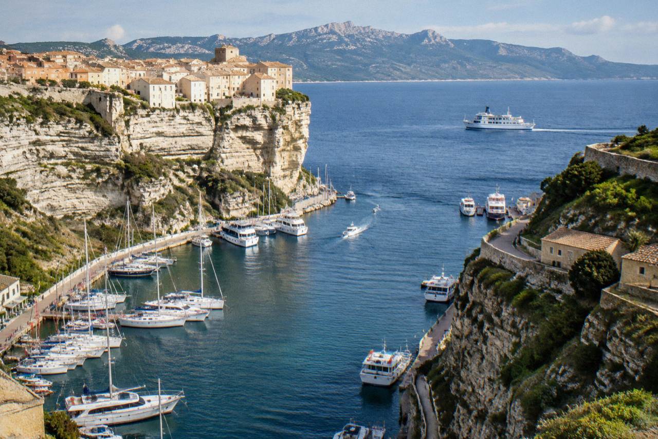 A ferry sailing on open Mediterranean water with mountainous Corsican coastline on the horizon