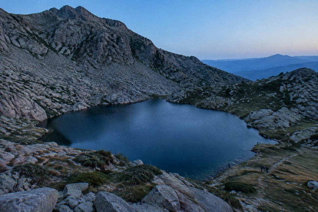 A rocky mountain ridge path in the Corsican interior under a clear sky