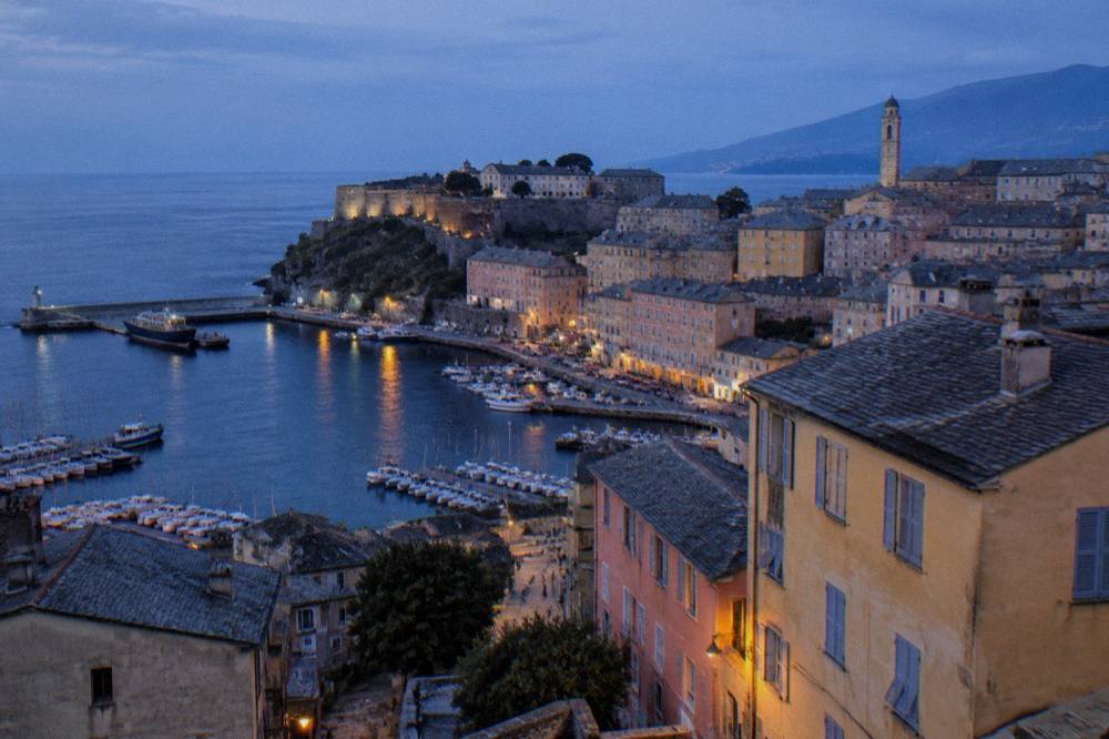 The citadel walls and bell tower of Bastia rising above the rooftops in evening light