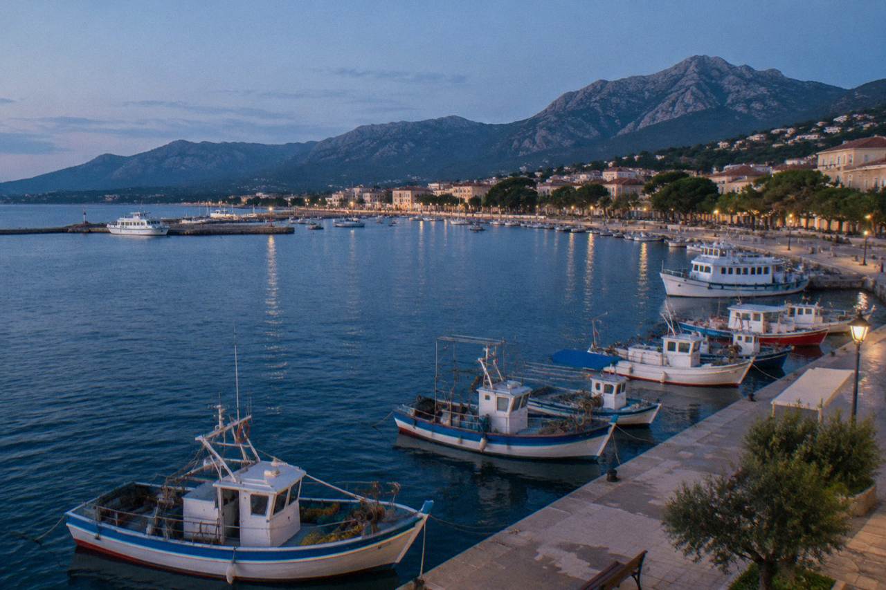 A harbour town on the Corsican coast with fishing boats moored along the quay