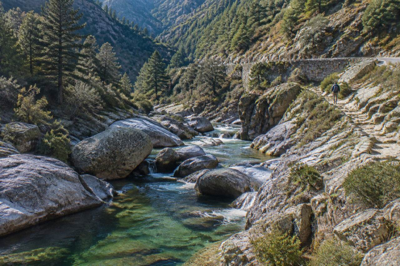 A stone trail winding through granite mountains in the Corsican interior