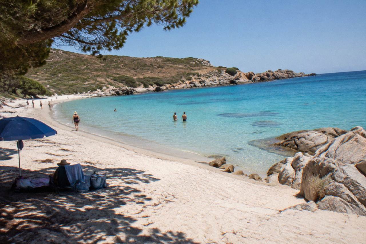 A calm swimming cove with clear water and rocky Corsican coastline in summer