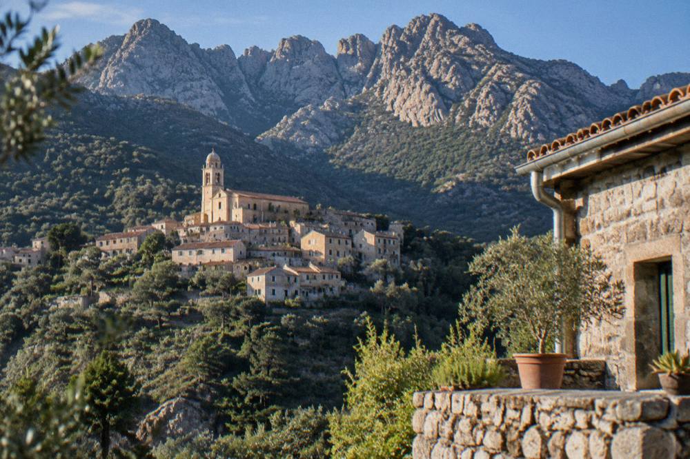 A mountain refuge of stone below bare granite peaks on the GR20 in Corsica