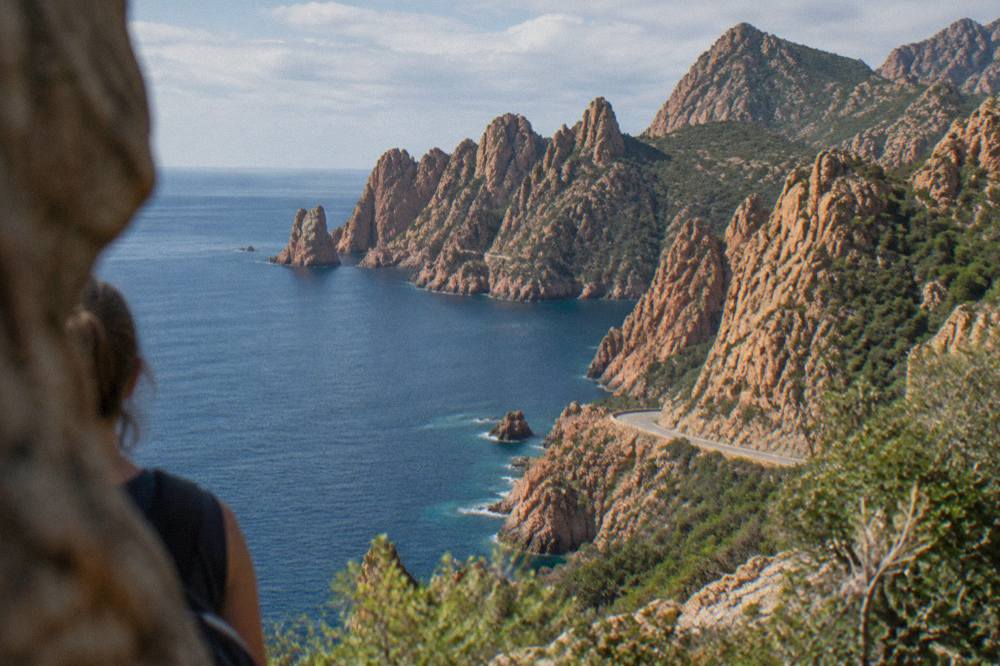 Red granite rock formations of the Calanques de Piana rising above the sea near the Golfe de Porto in Corsica