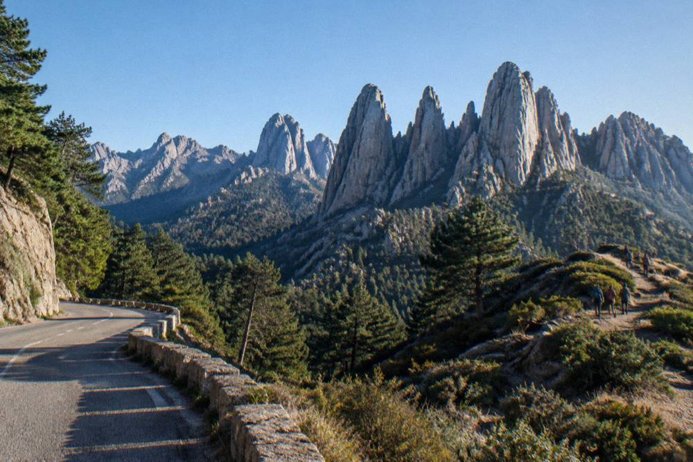 Tall granite rock spires standing in a row against a clear sky in the Bavella massif