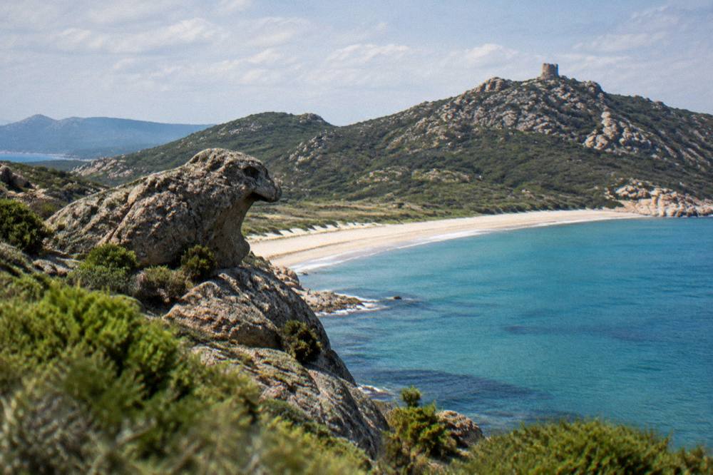 A viewpoint over the southern Corsican coastline with scrub covered hills and a turquoise bay