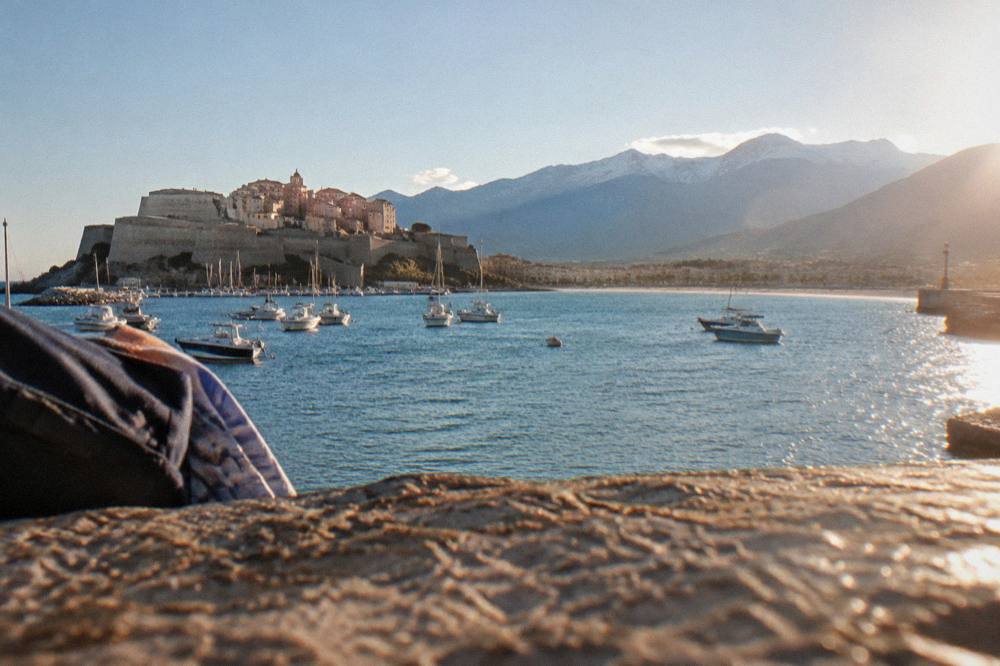 A sunny afternoon on the seafront of Calvi with the mountains in the background
