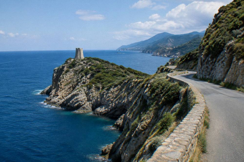 A coastal road winding along the Cap Corse peninsula with the sea on both sides