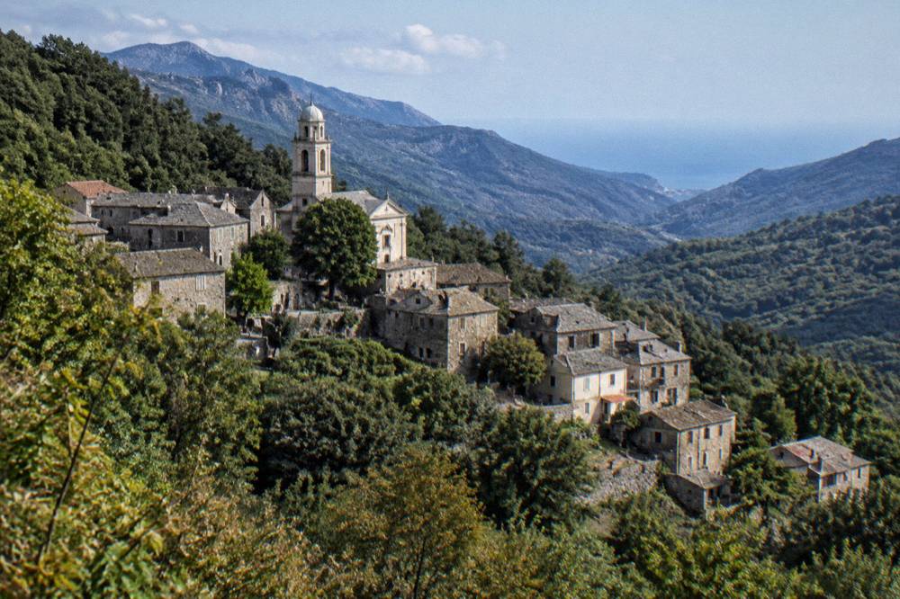 Stone village houses on a wooded slope in the Castagniccia in Corsica