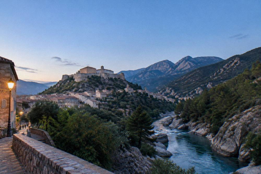 A mountain river running through a granite gorge with pine trees on the slopes