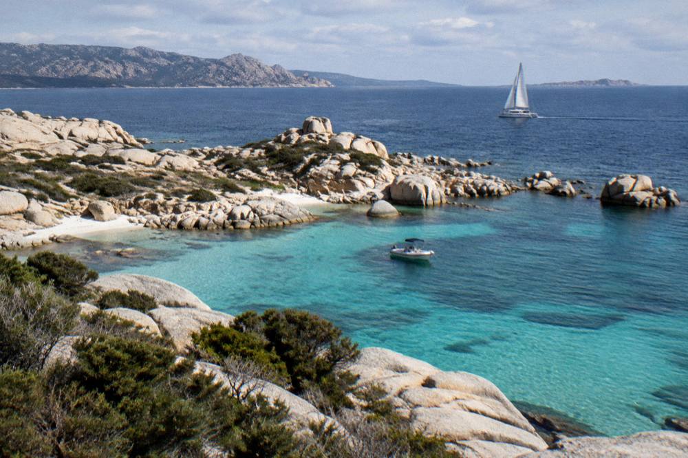 A catamaran under sail on open water between Corsica and the Lavezzi islands