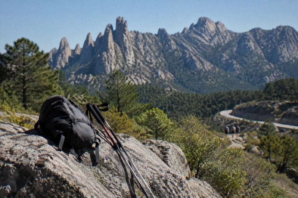 Walking equipment resting on a rock with the Bavella peaks in the background