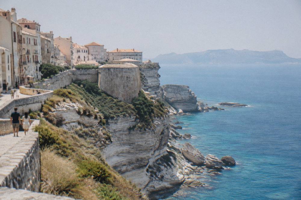 The cliff top walk above the sea with the coastline of a distant island on the horizon