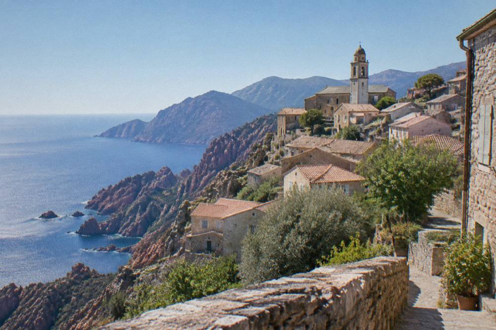 A mountain road winding between red granite pinnacles above a blue gulf