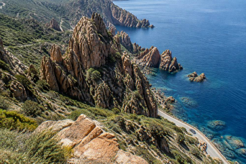 Coastal cliffs and clear water along the Calanques de Piana on a sunny day