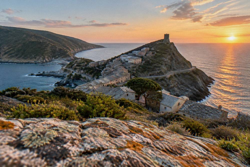Sunset light over the sea and rooftops of a Corsican coastal town
