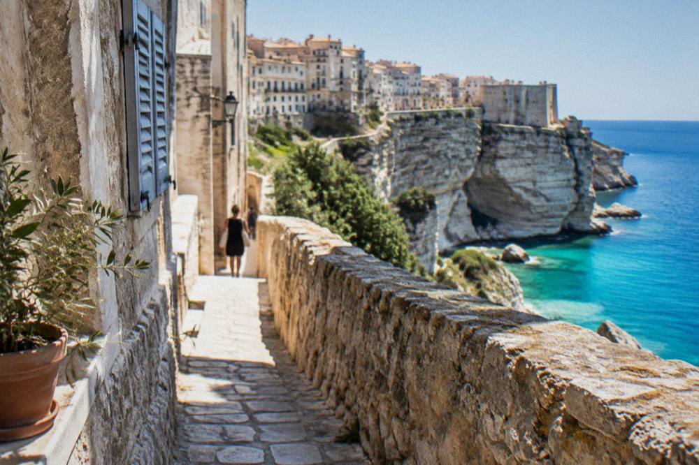 A narrow stone street with old walls in a Corsican fortress town