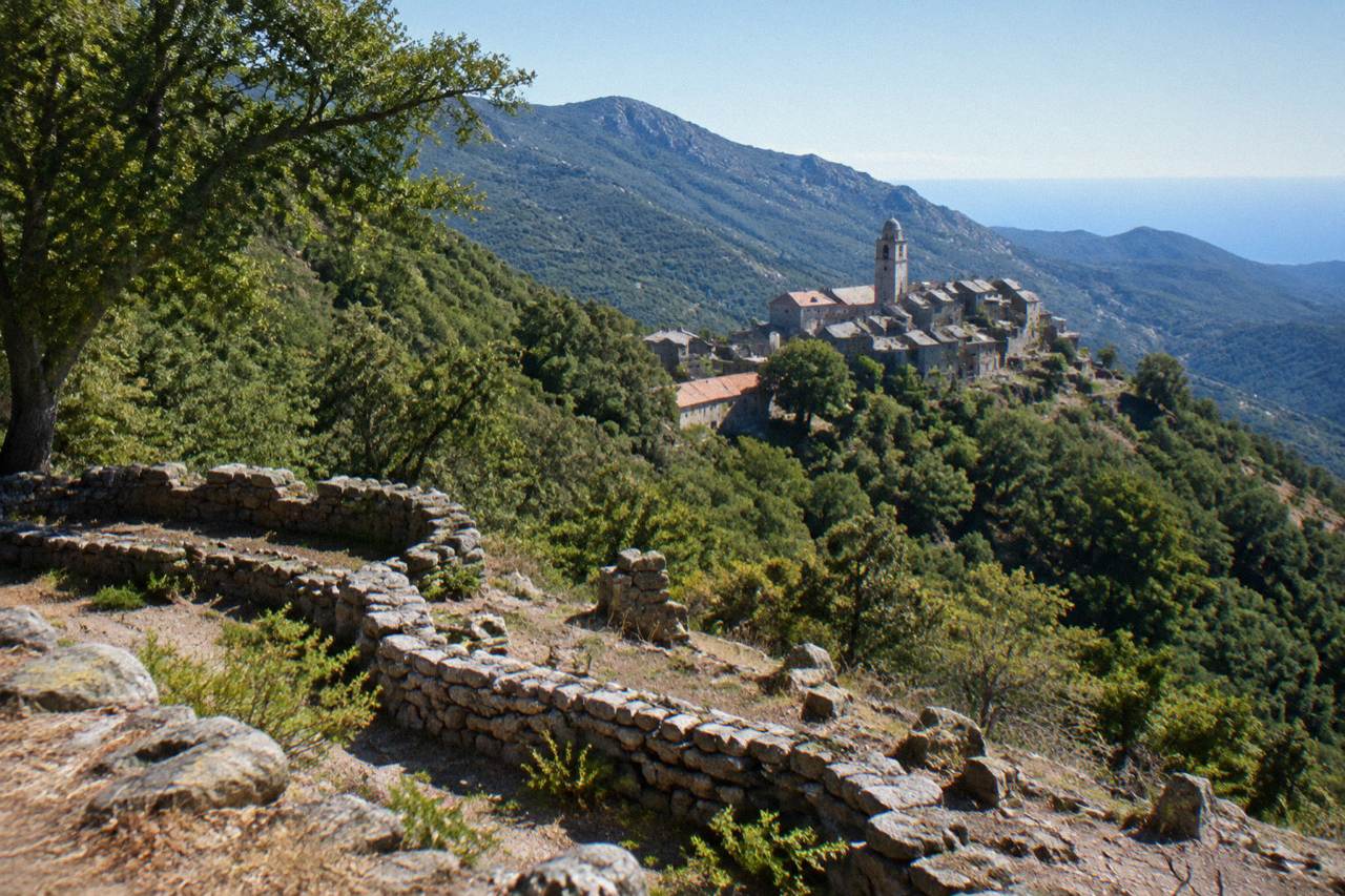 Stone ruins of a prehistoric site on a wooded hillside in southern Corsica