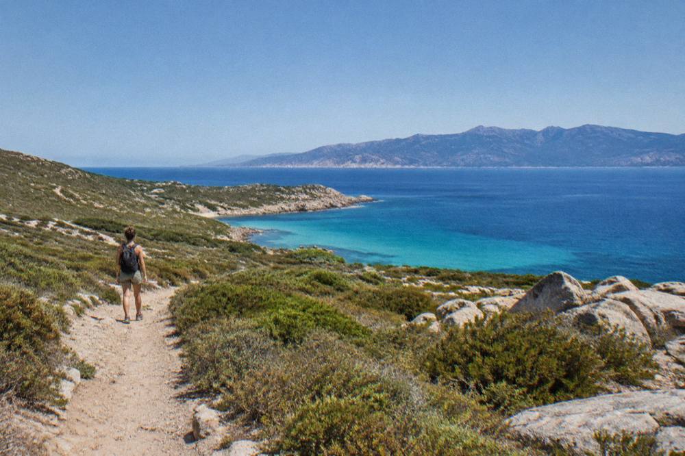 A viewpoint over the sea with mountains in the distance under a clear sky