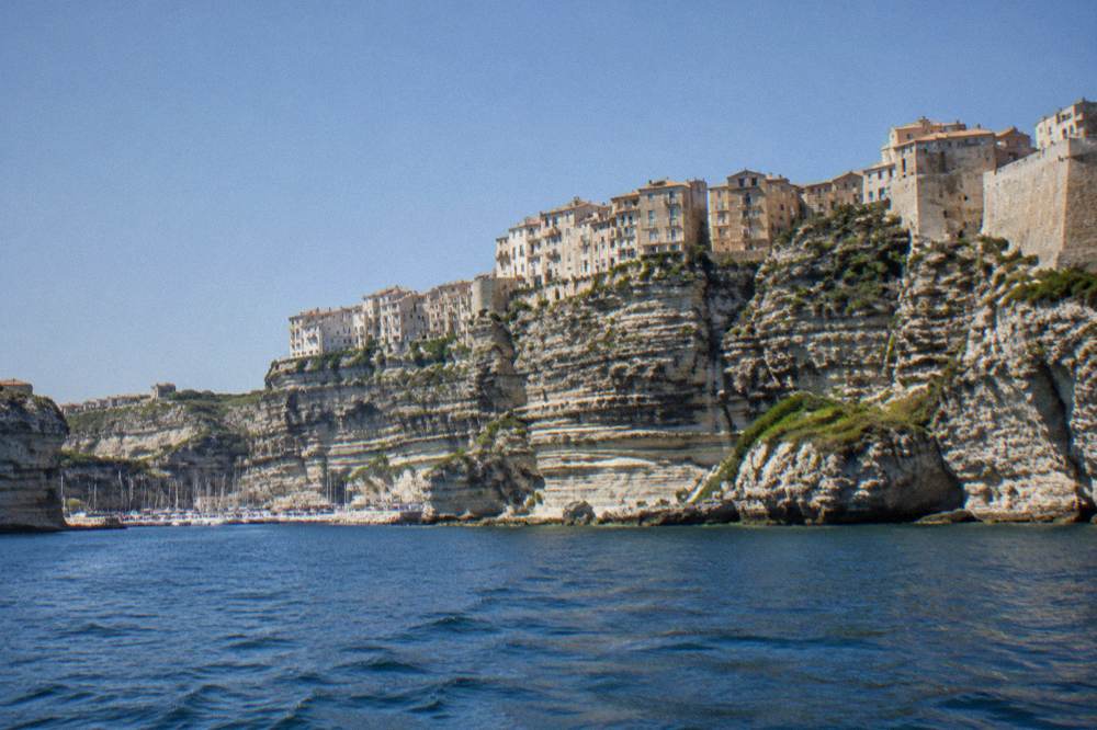 The harbour and cliffside houses of Bonifacio seen from the water on a clear day