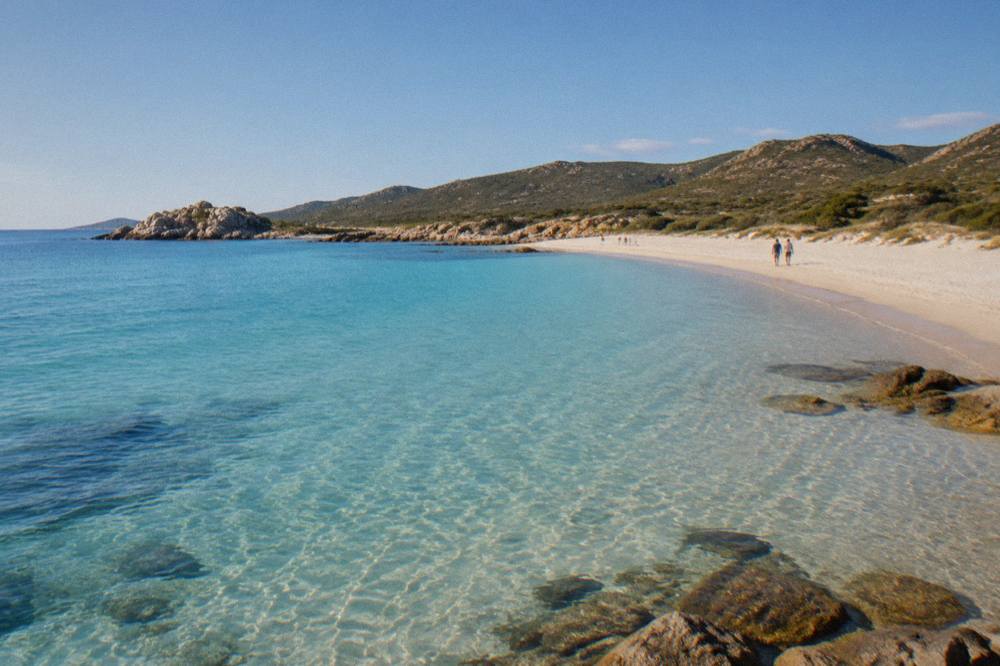 Clear shallow water over pale sand seen from above, with gentle ripples