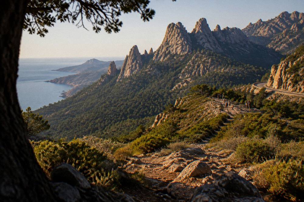 A view along a coastal path above the sea in southern Corsica with rocky ground and low scrub
