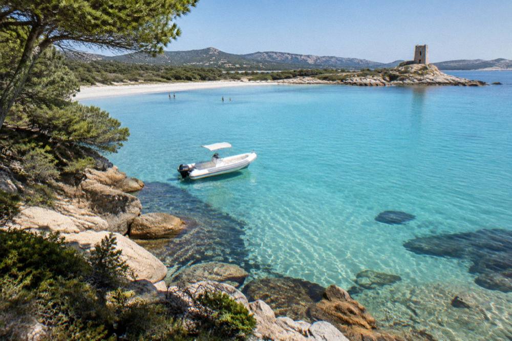 A small boat anchored close to a rocky Corsican shoreline with pine trees above the water