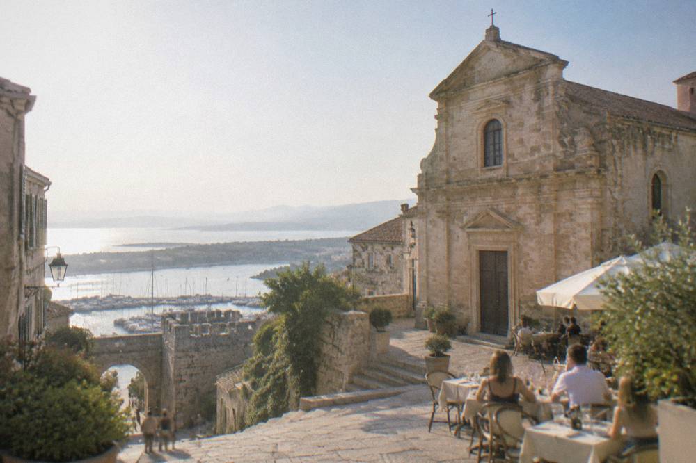 Evening tables set in a small square beneath the facade of a town church