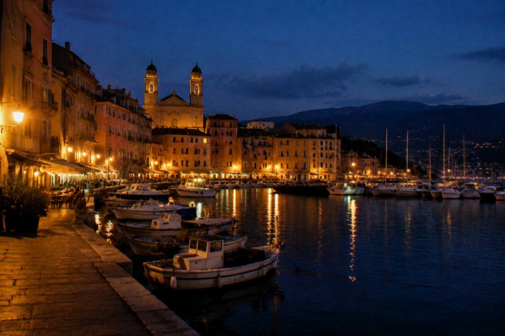 Harbour water and distant hills seen at dusk from a Corsican seaside town