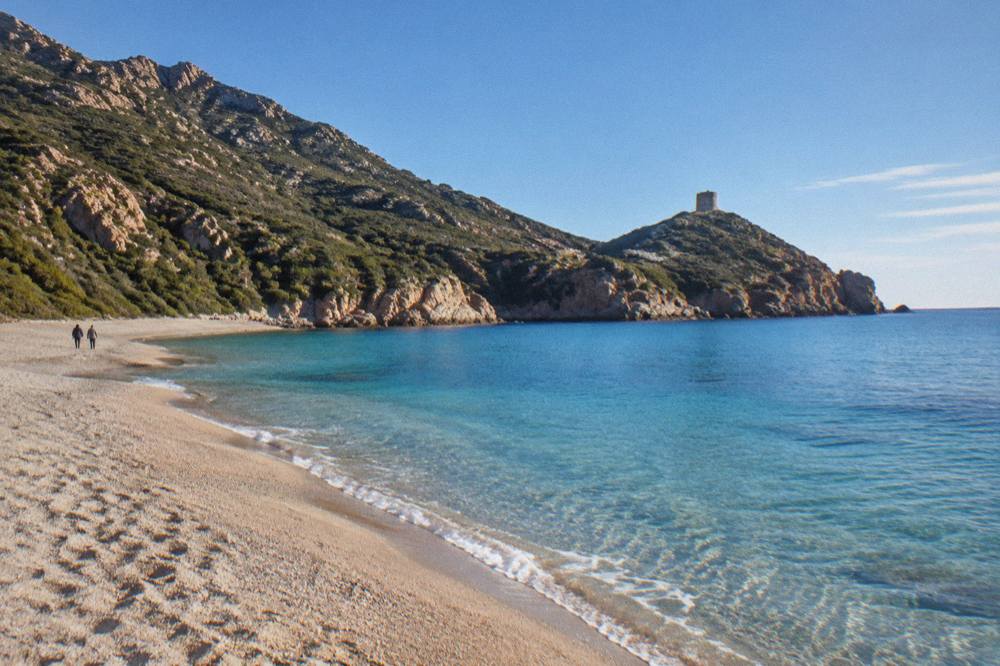 Turquoise shallow water over sand in a sheltered Corsican cove