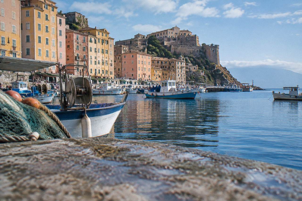 Fishing boats and stone buildings along the harbour of the old port in Bastia, Corsica