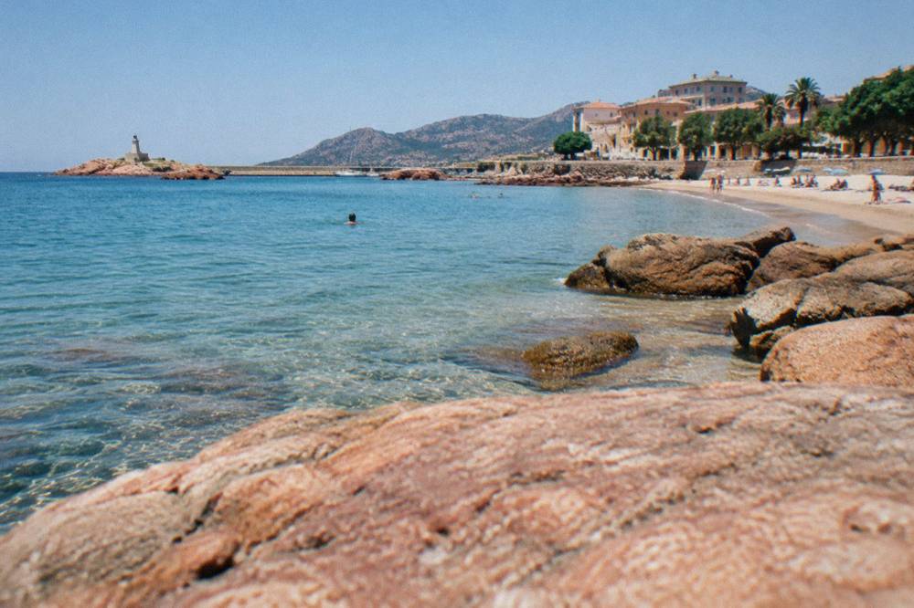A sandy beach with clear water on the Balagne coast of Corsica near L'Île-Rousse