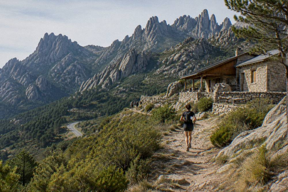 A mountain refuge building of stone and wood beside a trail in the Corsican mountains