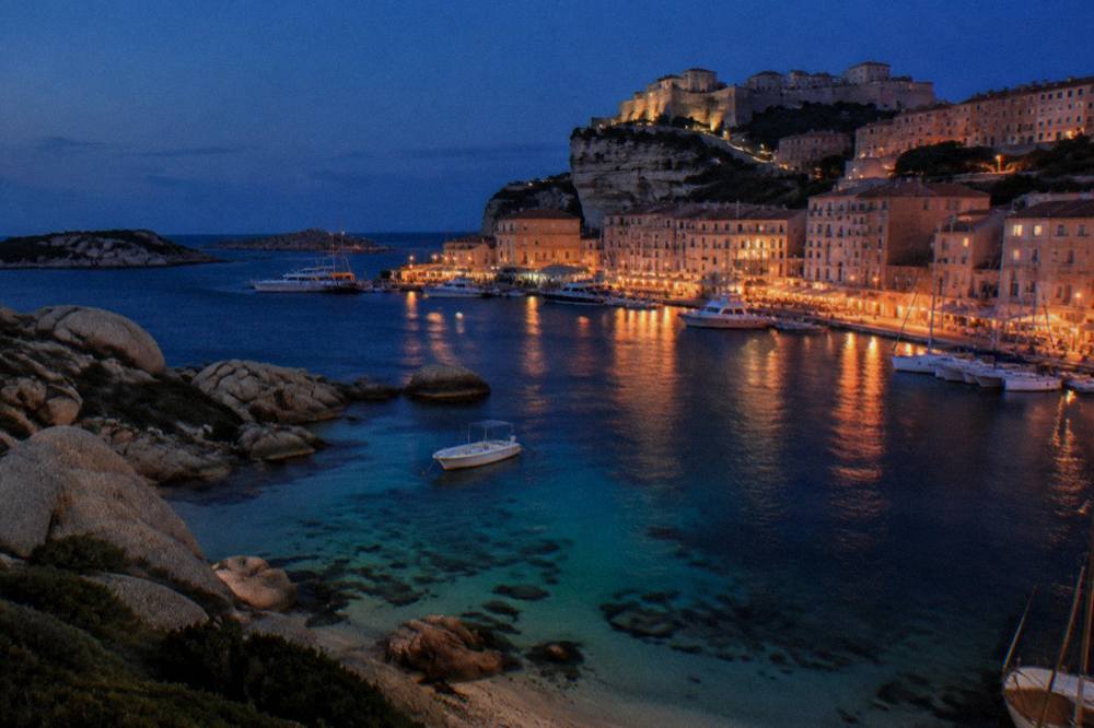 A harbour town at dusk with boats moored along the quay