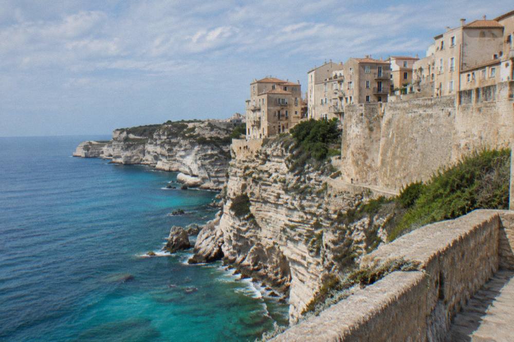 White limestone cliffs below the Bonifacio citadel rising above blue water