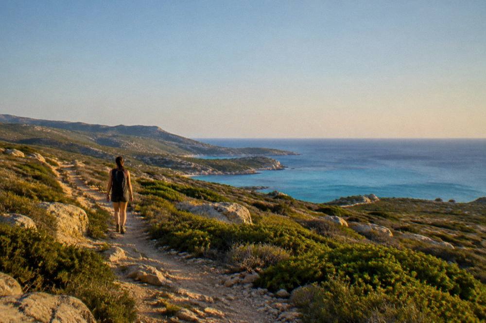 Low green scrub and rocky ground stretching to a distant blue sea
