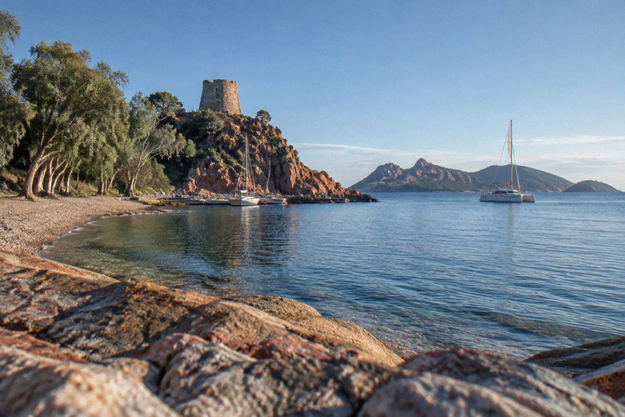 A catamaran sailing on clear water near the islands south of Porto Vecchio