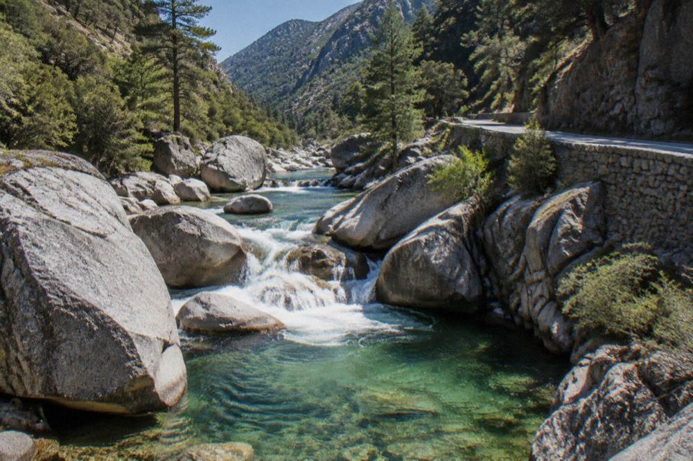 A clear river flowing between granite walls in the Restonica valley near Corte