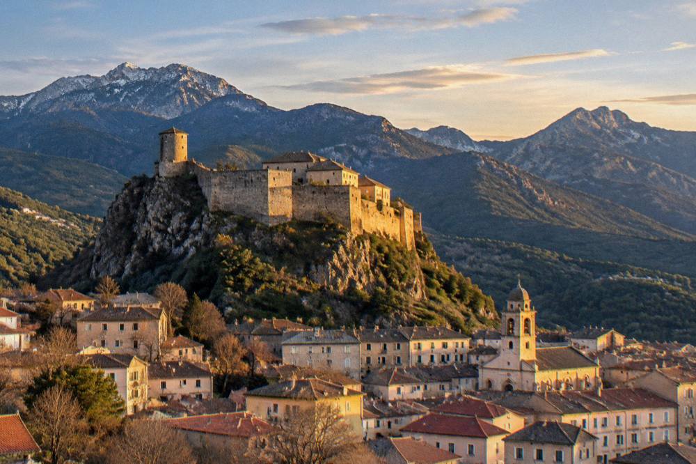 Evening light on the citadel of Corte with mountains behind the town