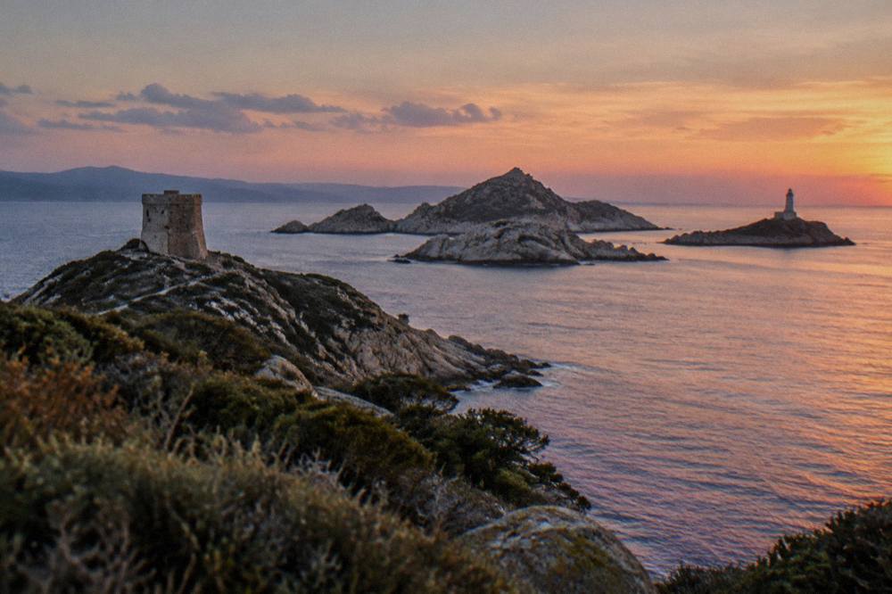 Granite islands with a lighthouse at the entrance to a Mediterranean gulf seen from a boat