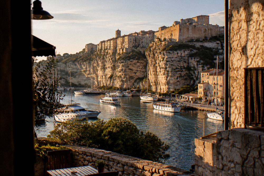 A hilltop Corsican town above a coastline at golden hour