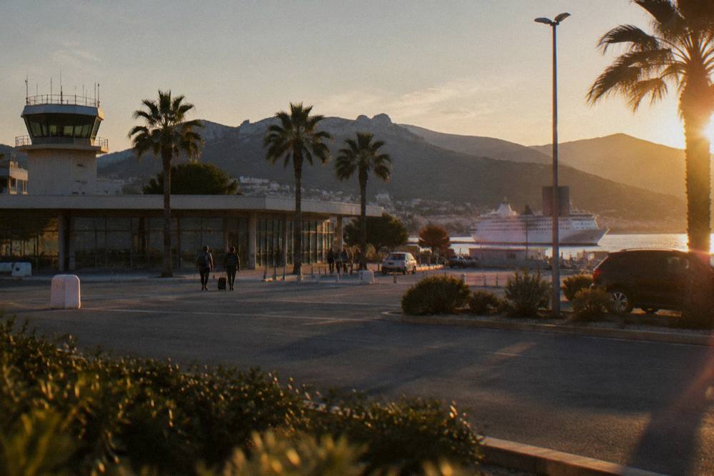 A white ferry ship docked at a Mediterranean port town in evening light