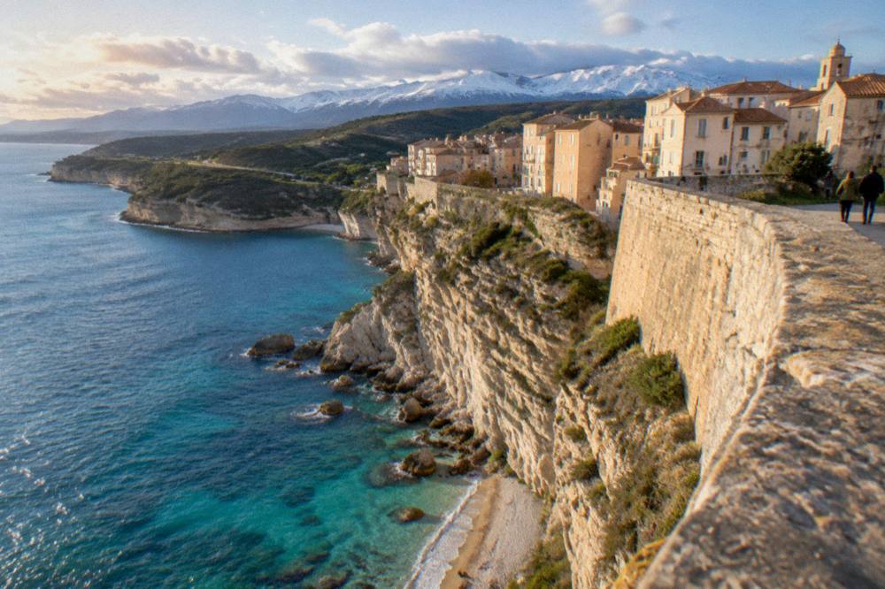 A stone citadel above a coastal town under a winter light
