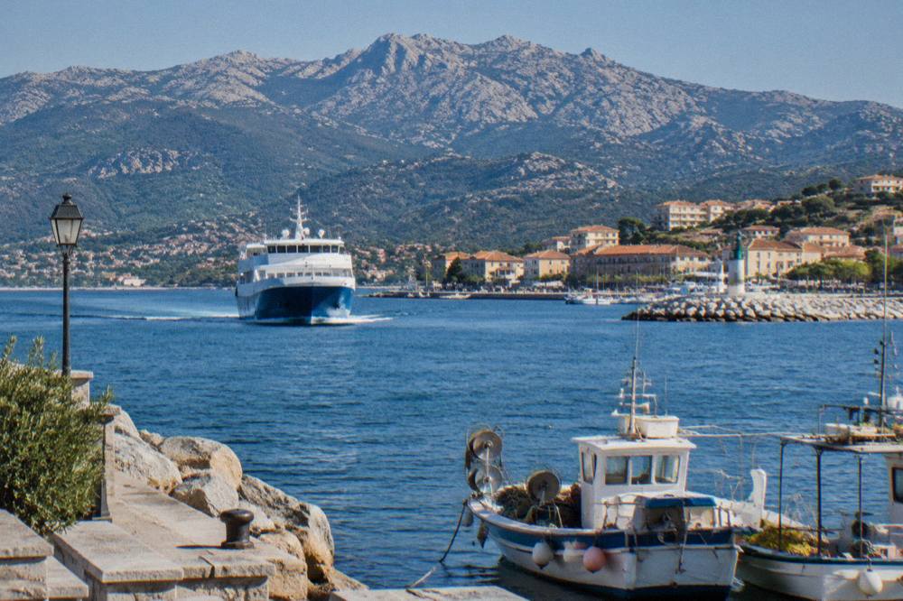 A ferry approaching a Corsican harbour town at morning