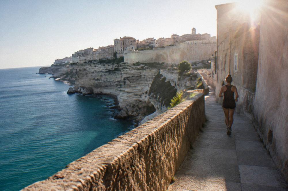 White limestone cliffs above a narrow strait with a fortress town on the headland