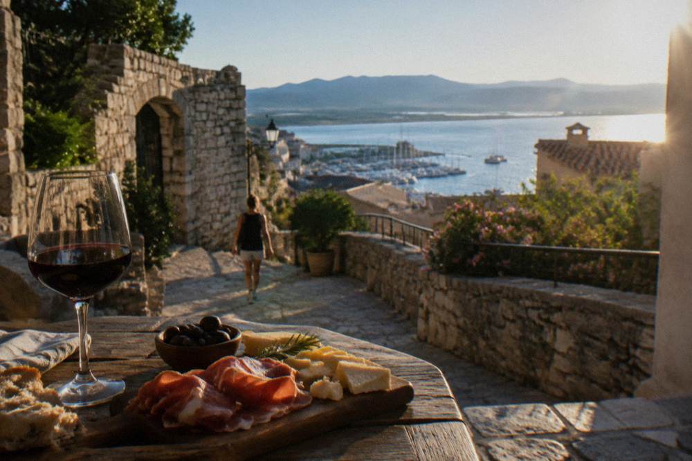 A Corsican tasting board with ham, cheese and a glass of red wine