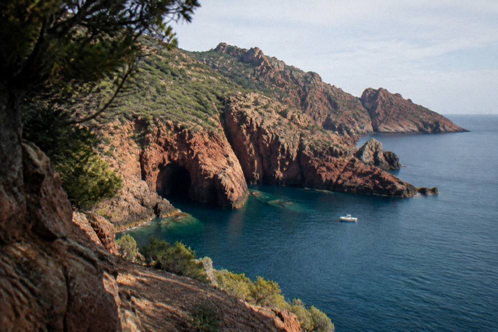Red granite cliffs above blue water on the Corsican coast